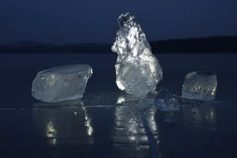 Reflection of sun rays in flat ice on the lake. Air bubbles Stock Photos