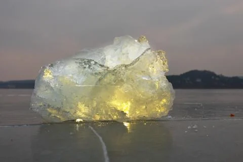 Reflection of sun rays in flat ice on the lake. Air bubbles Stock Photos