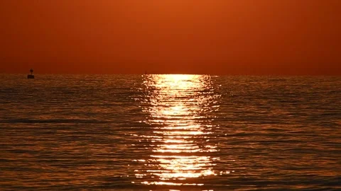 Reflection of sun rays on sea water. Sun setting on the ocean during sunset Stock Footage 138033357
