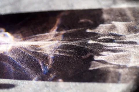 Reflection of sun rays on the table from a glass of water Stock Photos
