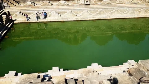 Reflection of Sun Temple the green water of Sun Kund (water reservoir) Stock Footage 116114434