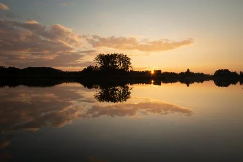 Reflection of the sunset and clouds in the lake Stock Photos