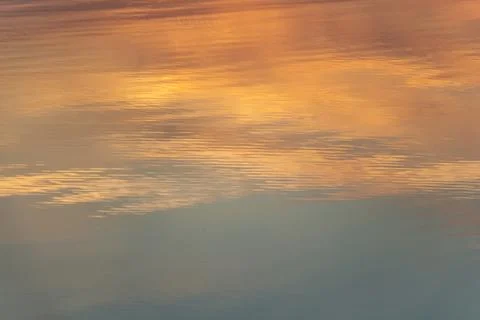 Reflection of sunset and dawn in the river, orange and blue sunset colors Stock Photos