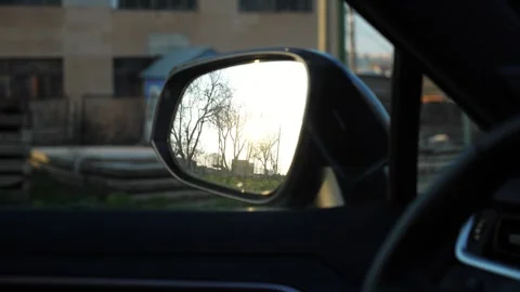 Reflection of a sunset in a car side mirror, showcasing the gradual transition Stock-Footage 321778368