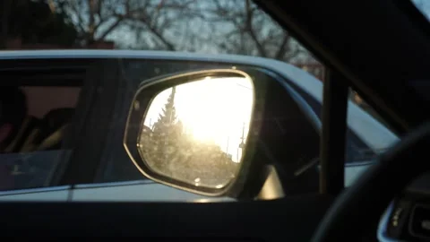 Reflection of a sunset in a car side mirror, showcasing the gradual transition Vidéo 347874772