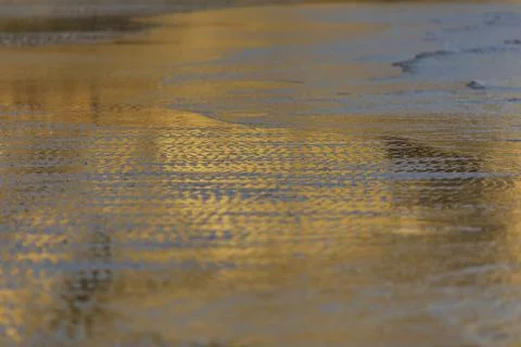 Reflection of the sunset on the coast of the sea Stock Photos