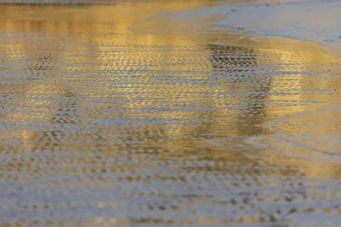 Reflection of the sunset on the coast of the sea Stock Photos