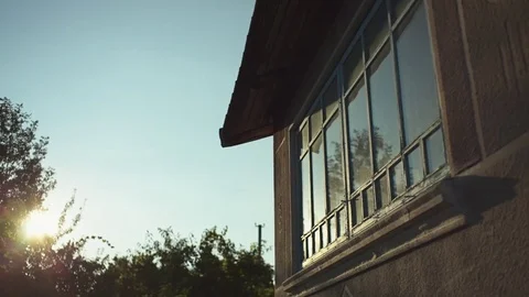 Reflection of the sunset, dawn in the window in an old hut in the countryside. Stock Footage 81668069