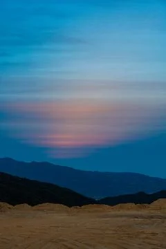 Reflection of sunset in a field over a mountain range Stock Photos
