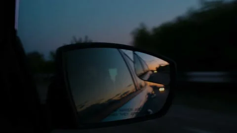 Reflection of the sunset in the rearview mirror of a car. Travel by car. Car Stock Footage 212425293