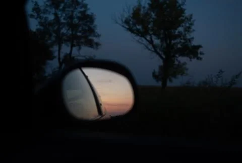 Reflection of sunset in the side mirror of the car. Stock Photos