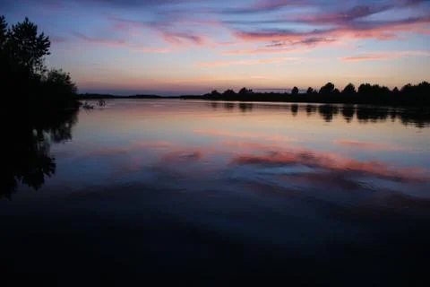 Reflection of the sunset sky in the river in the summer. Stock Photos