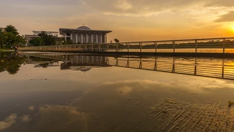 Reflection of sunset on wet sidewalk with Sultan Mizan Mosque Time lapse Zoom Video stock 96133542