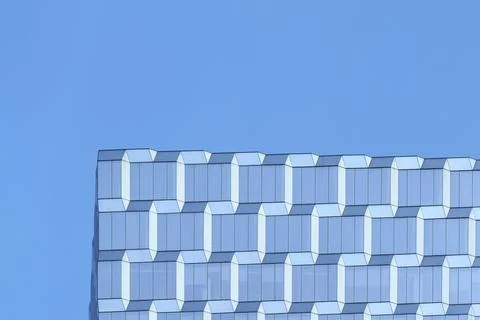 Reflection on the surface of a modern glass office building against blue sky Stock Photos