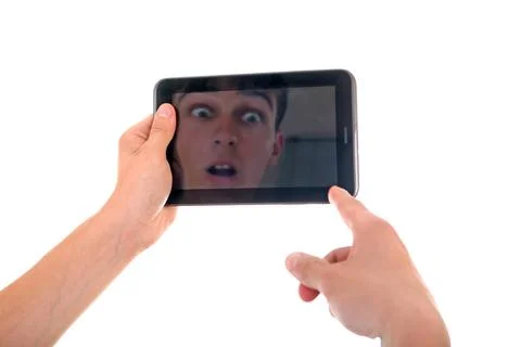 Reflection in Tablet Computer Reflection of Surprised Face in Display of T... Stock Photos