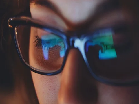 Reflection of a Tablet Screen in Woman Glasses at Night. SLOW MOTION 4K DCi 動画素材 75667647