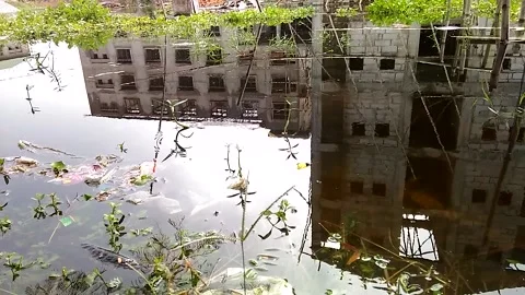 Reflection of a tall buildings on the surface of water during a sunny day Stock Footage 132895307