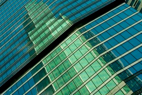 Reflection of a tower of a skyscraper in a glass building of another skyscrap Stock Photos