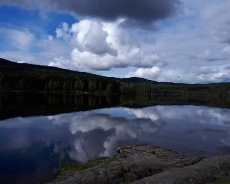Reflection of trees and sky in blue water Stock Photos