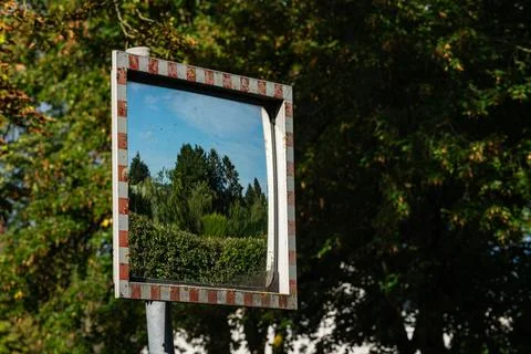 Reflection of trees and sky in a road mirror Foto stock