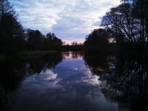 Reflection of trees, clouds and sunset in the river Stock Photos
