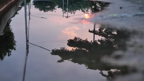 Reflection twilight sunset sky in puddle water flooding on street Stock Footage 90479987