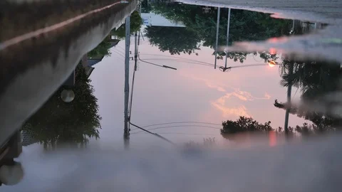 Reflection twilight sunset sky in puddle water flooding on street Stock Footage 93469973