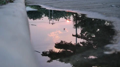 Reflection twilight sunset sky in puddle water flooding on street Stock Footage 113880559