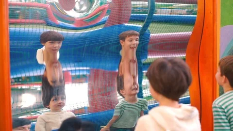 Reflection of two brothers in a distorted mirror. Stock Footage 120600203