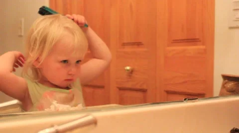 Reflection of a two year brushing her hair Stock Footage 41651870
