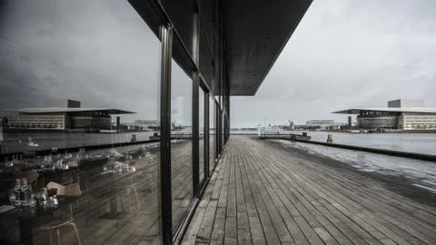 Reflection view overseeing a pier next to water and a modern building Stock Photos