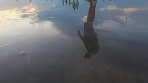 Reflection on walking man on beach in low tide Stock Footage 153732554