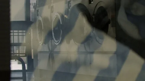 Reflection of washing machines through a spinning dryer Stock Footage 117626594