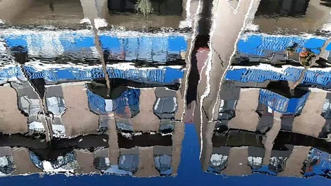 Reflection in water of an apartment building in waves Stock Footage 128279519