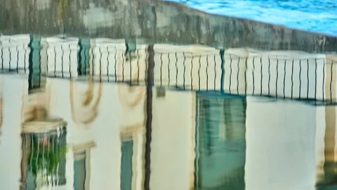 Reflection in the water of an old building and a metal fence. Stock Footage 112783478