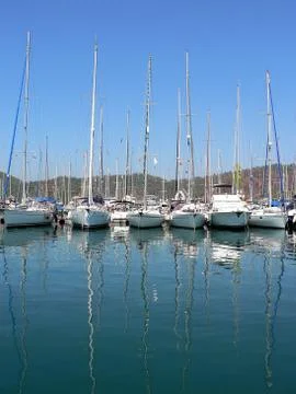 Reflection in the water of yachts. Stock Photos