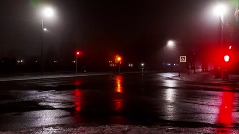 Reflection in wet asphalt at an intersection light from traffic lights at night 스톡 동영상 293685042