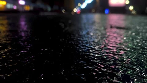 Reflection in wet asphalt at an intersection light from traffic lights at night  Stock Footage 329932180