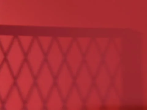 Reflection of white bars on a red wall. geometric shadows on the wall. 스톡 사진