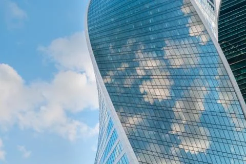 Reflection of white clouds and blue sky in glass wall of modern skyscraper Foto stock