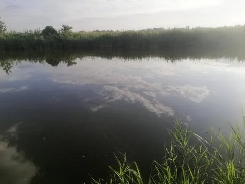 Reflection of white clouds on calm river forms natural harmony. blue sky is.. Stock Photos
