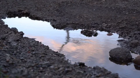 Reflection of a windmill in a puddle on the road. Video stock 105680888