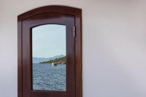 Reflection in a window on board of a boat showing the view over the sea Fotos de archivo