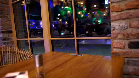 Reflection in the window of a restaurant where people are sitting at tables Stock Footage 266979006