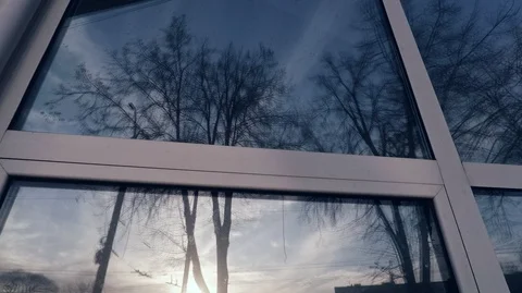 Reflection in the window trees without leaves against the blue sky and setting Stock Footage 125817224