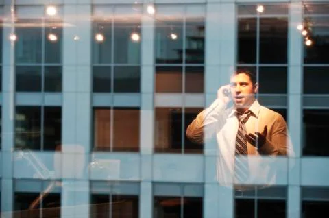 Reflection in windows of a businessman working late at night Stock Photos