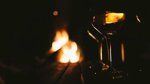 Reflection of wineglasses in a row with fireplace in the background Stock Footage 275245477