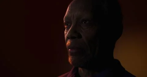 Reflection of wisdom in an elderly mans face in dim light setting Stock Illustration