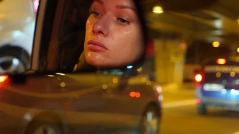 Reflection of a woman's face with blue eyes in rearview mirror, woman behind the Stock Footage 81349412