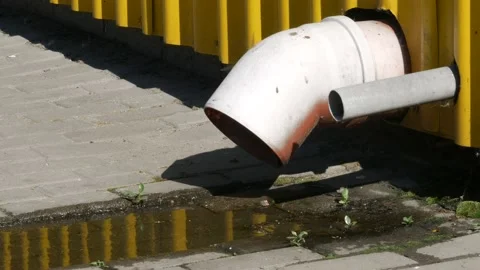 Reflection of the yellow cladding of building with steel sheets. Draining water Stock Footage 138577130